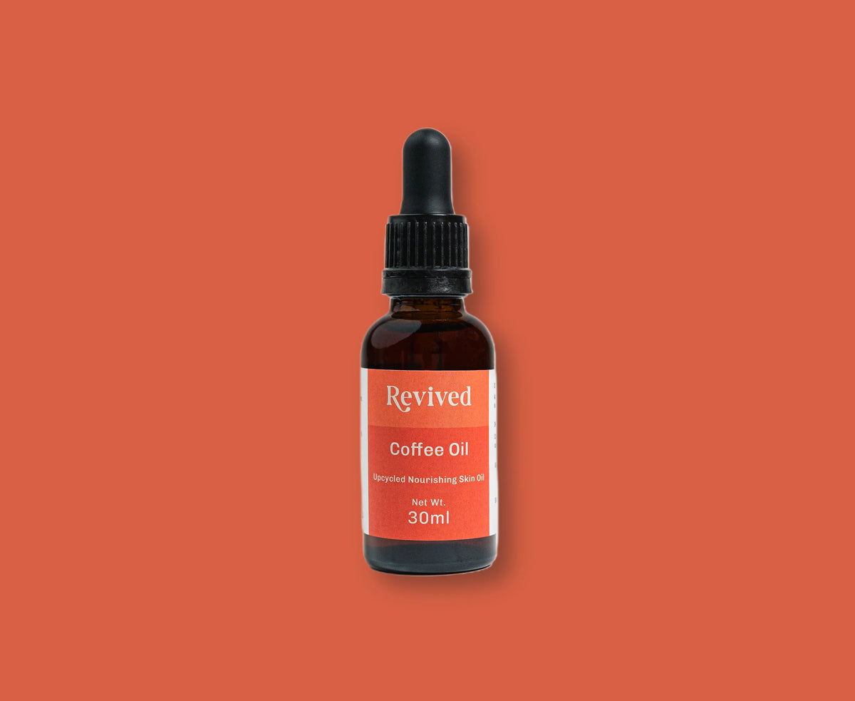 Bottle of Revived Coffee Oil on a solid terracotta background