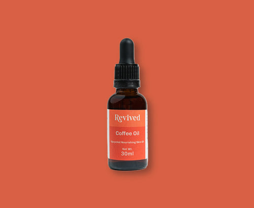 Bottle of Revived Coffee Oil on a solid terracotta background