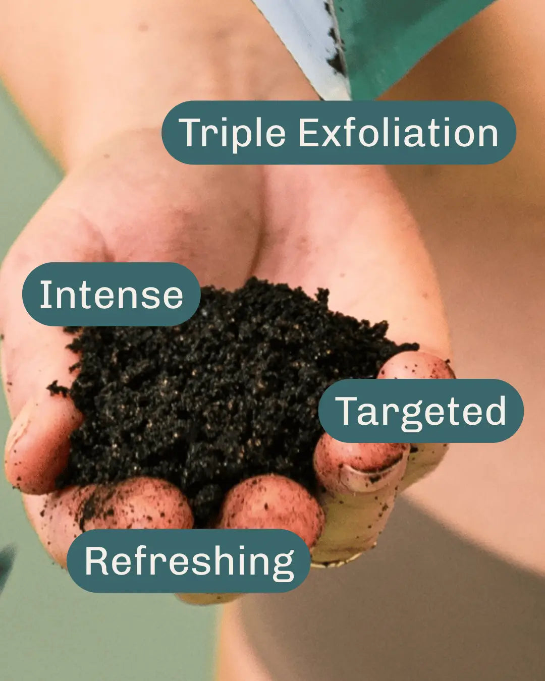 A close-up of a hand holding dark invigorating peppermint exfoliating  body scrub, with text labels reading 'Triple Exfoliation', 'Intense', 'Targeted', and 'Refreshing' overlaid on the photo.