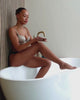 a model opens and enjoys the smell of Revived peppermint scrub as she exfoliates her leg with it