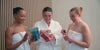 group of females opening different revived products and enjoying them as they use them in the bathroom.