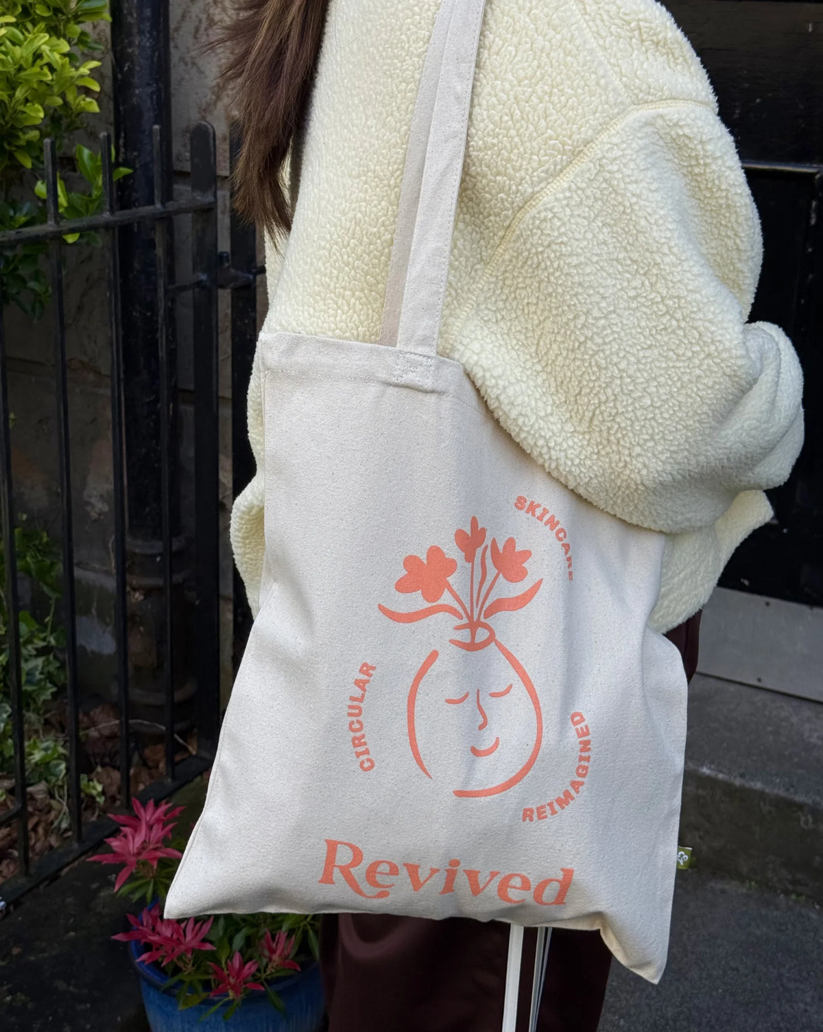 Revived wellbeing icon tote bag slung over the shoulder full length image